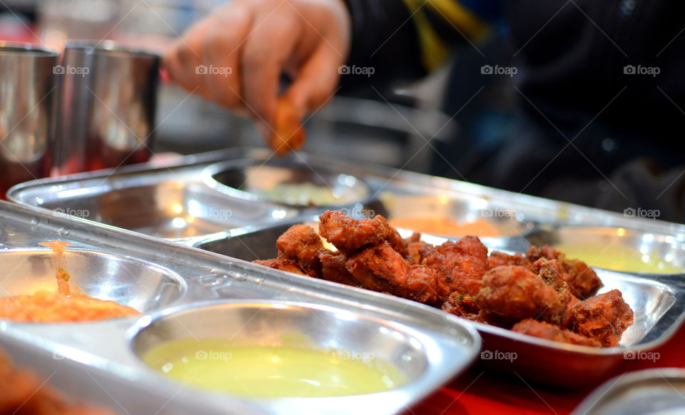 Person's hand eating fried fish