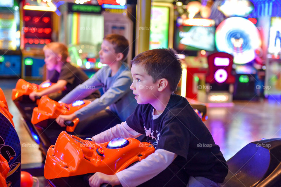 Young boy at an arcade on a video game motorcycle