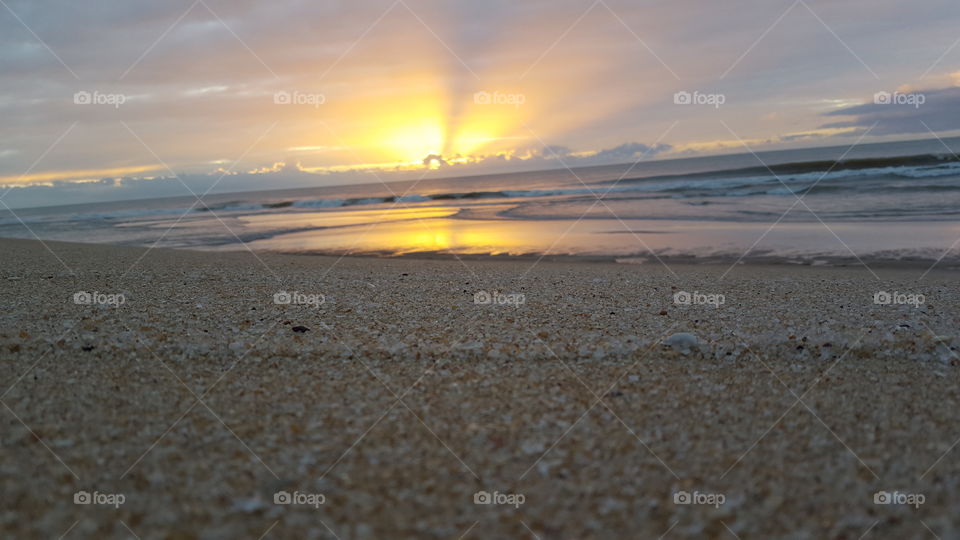 Nascer do sol numa praia deserta