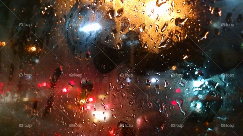 Close-up of wet bus window during rainy season