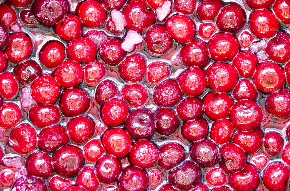summer is a time of ripe berries! background of Cherry jam. Close up of simmering homemade cherry jam. Cherry and sugar crystal