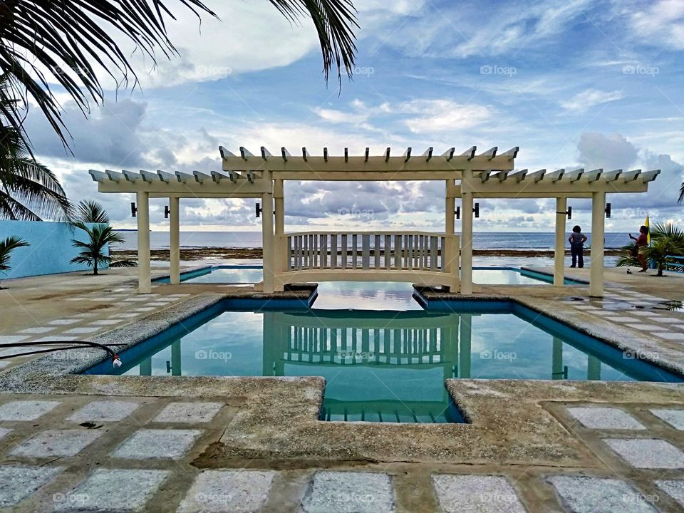 Swimming pool facing the Pacific Ocean with creative wooden design of bridge.