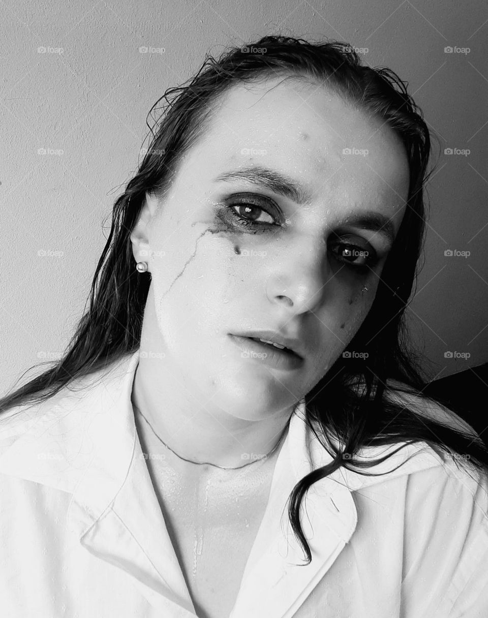 black and white emotional portrait of a girl with smeared makeup and tears, the photo evokes sadness