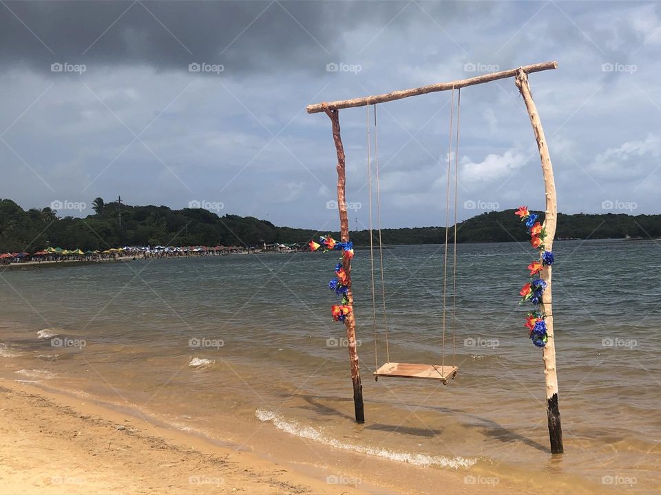 Swing at the beach decorated with flowers