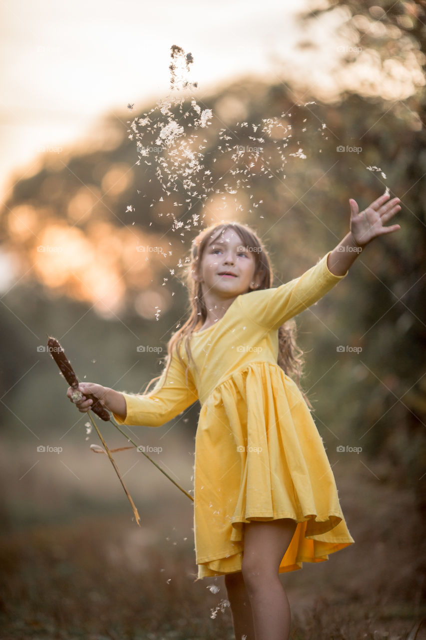 Little girl in yellow dress outdoor portrait at sunset 