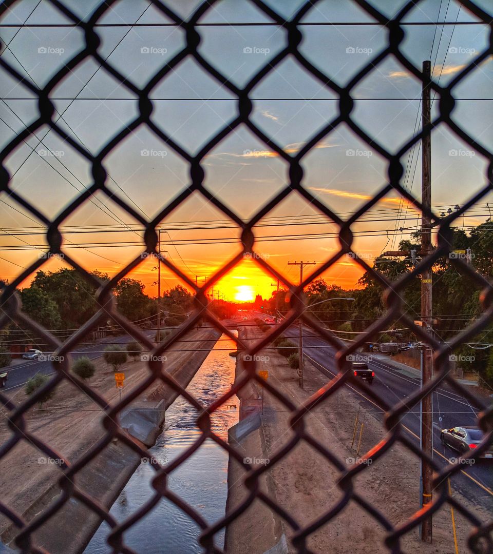 Sunset through a chain link fence