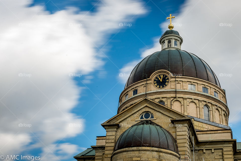 The dome of an old Basilica in Milwaukee Wisconsin with a bright blue and cloudy sky background