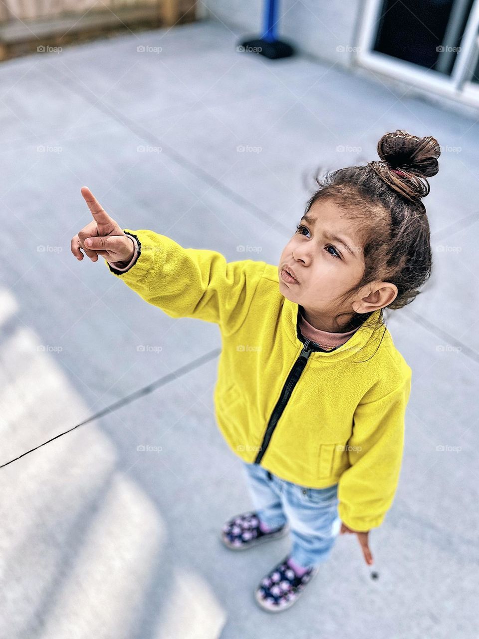 Little girl pointing up at the sky, little girl spotting planes and birds, toddler looks for birds in the springtime, toddler pointing up with concerned expression, toddler girl pointing to a plane in the sky