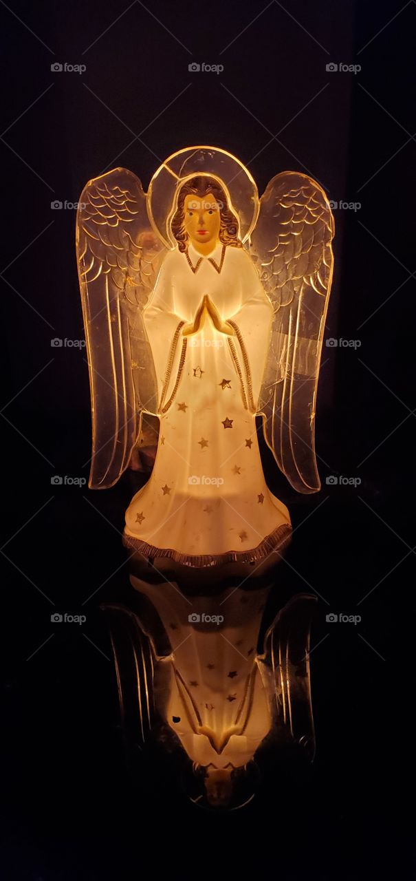 Angel tree topper now used as a glass table light. Was on top of Christmas tree for years & has always been lit.