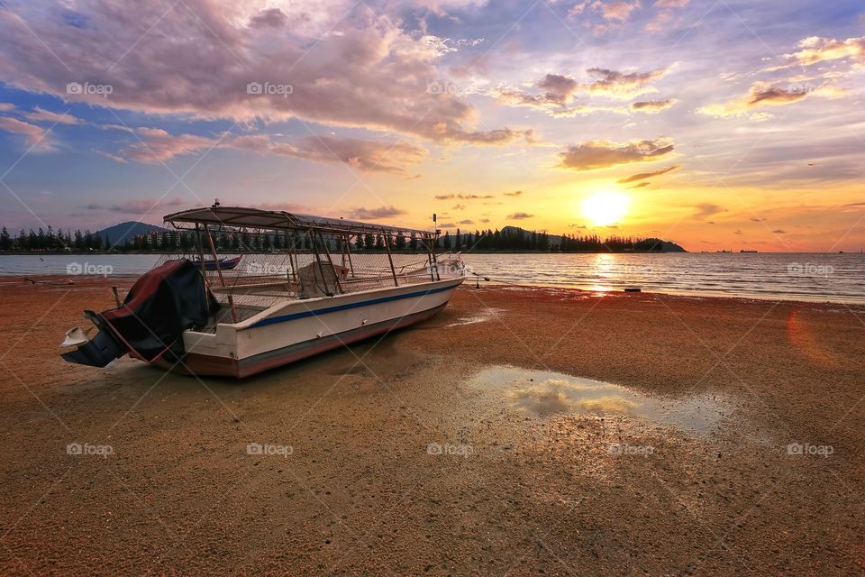 Fisherman boat at the beach with sunset background