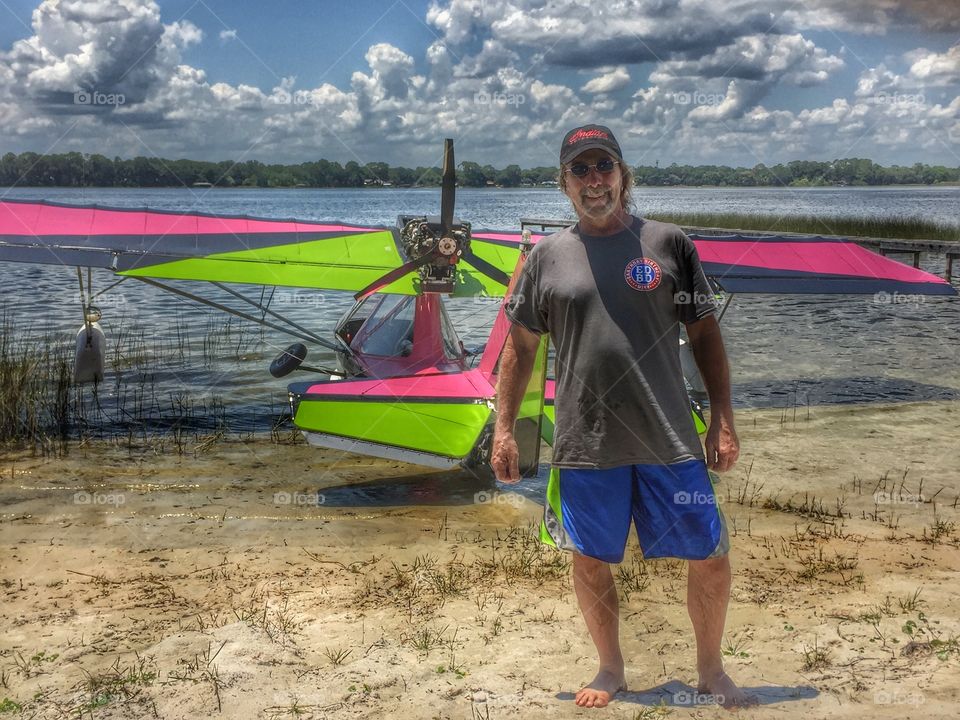 Senior man standing in front of boat