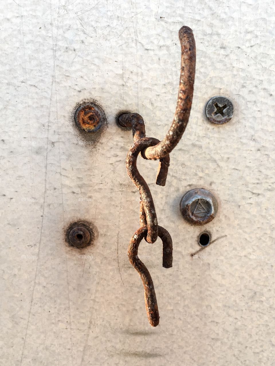 Antique old rusted chain hanging from hook closeup image