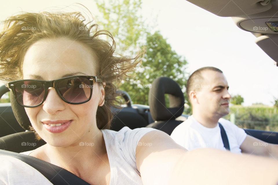 young couple in convertible. young couple enjoying summer ride in convertible car