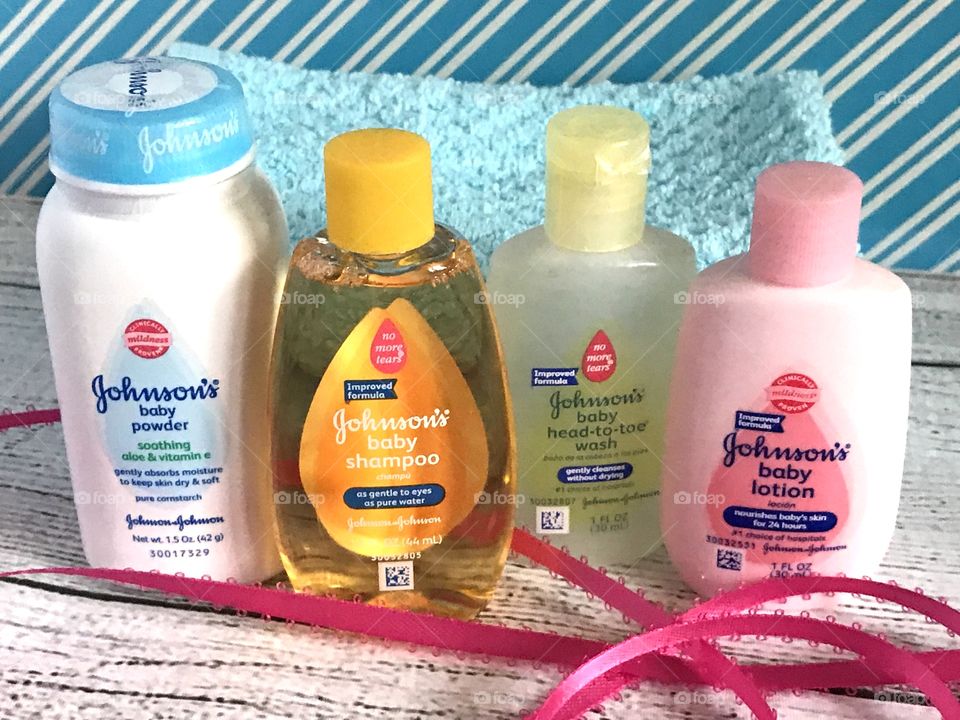Johnson and Johnson baby lotion, shampoo, head to toe wash and powder on a blue and white background with a pink ribbon 