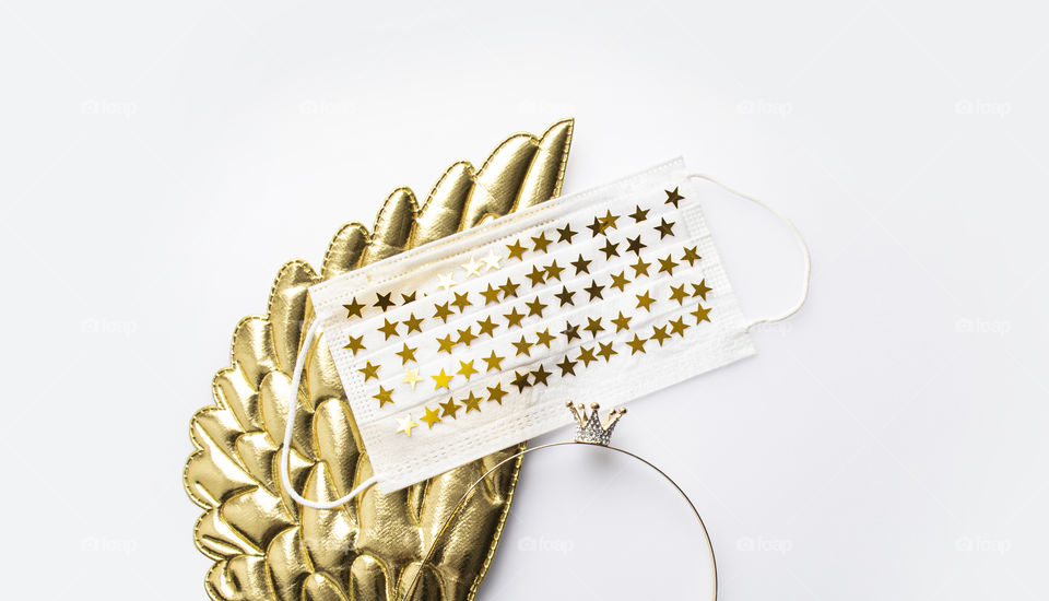 Golden wings, little crown and face mask with golden stars. New normal. Beautiful protection