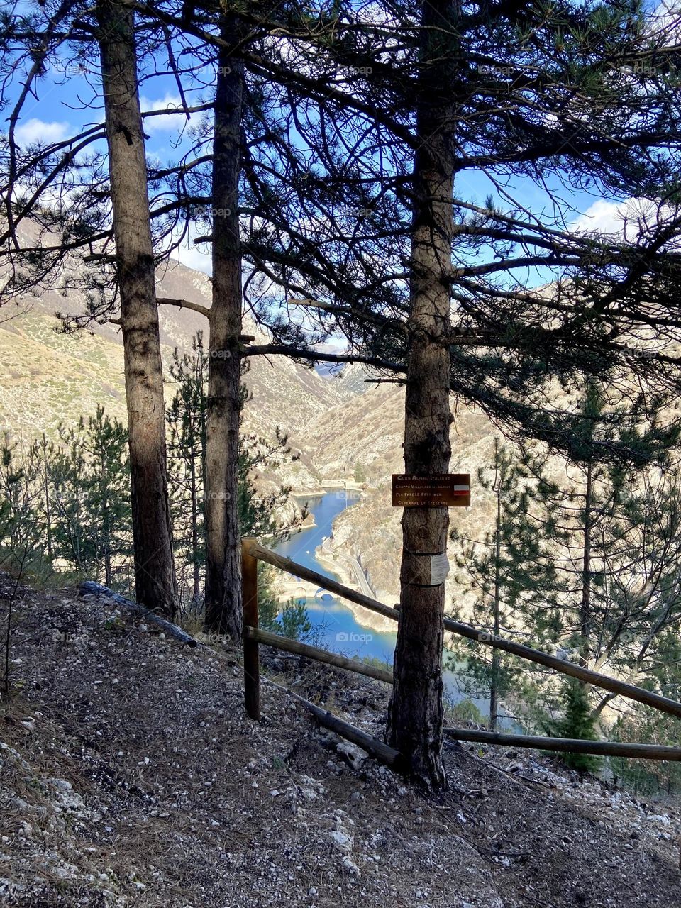Beautiful view from a path: a river between big mountains and green trees
