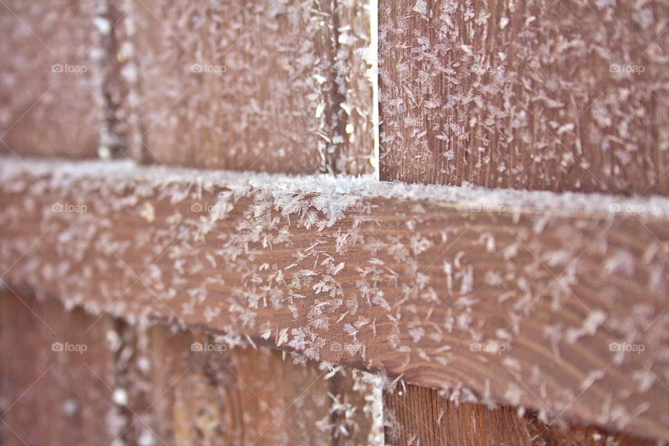 Texture. Fragment of a wooden fence covered with frost.