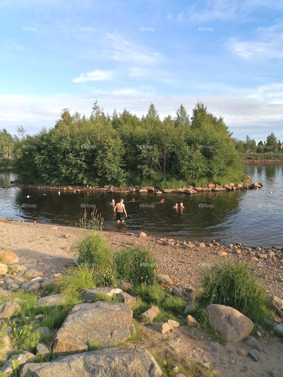 Summer day by the sea. People swimming.