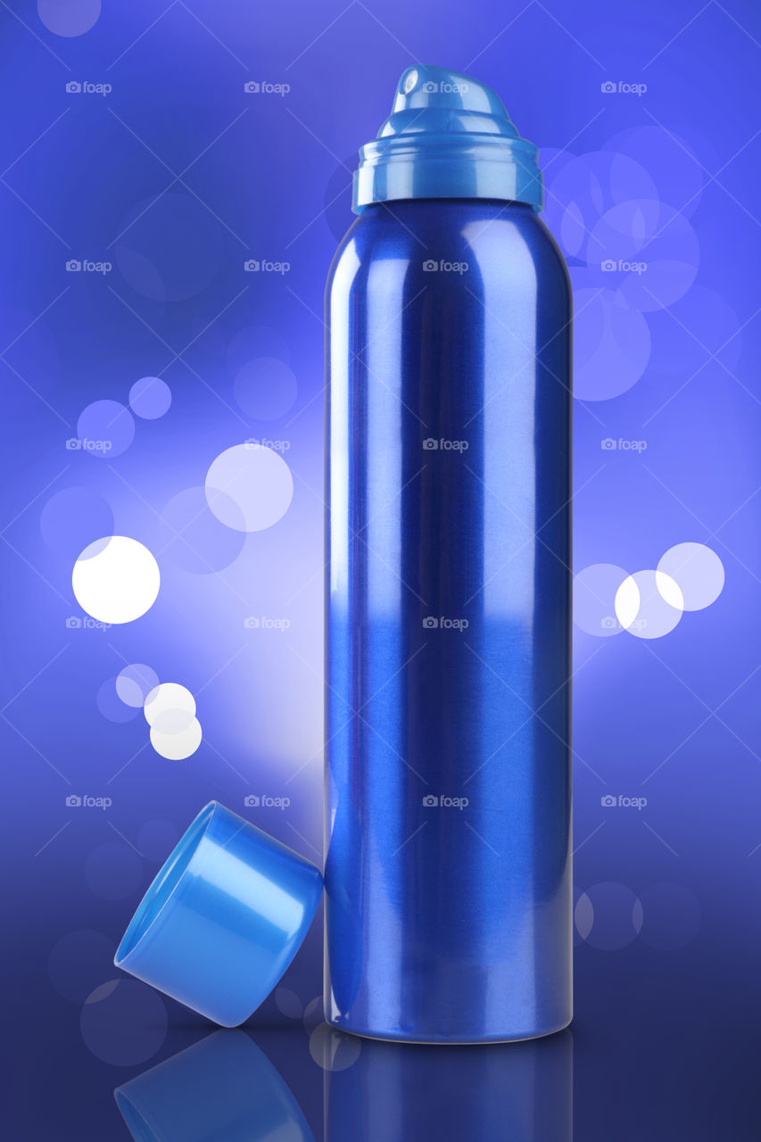 Blue deodorant can on blue bokeh background