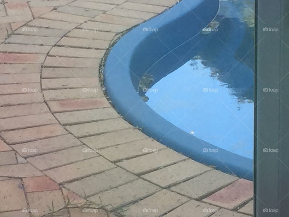 Edge of a pool with bricks and water