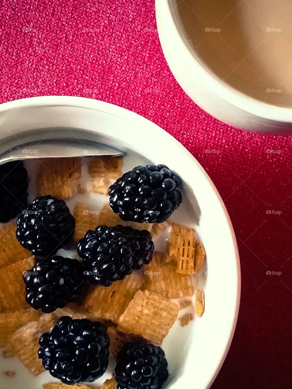 Bowl of cereal with blackberries and coffee with cream morning routine