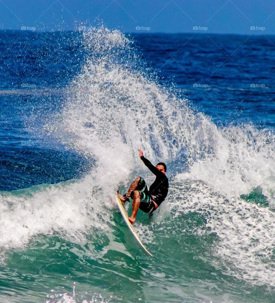 surfista em dia ensolarado na praia brava de Boiçucanga.