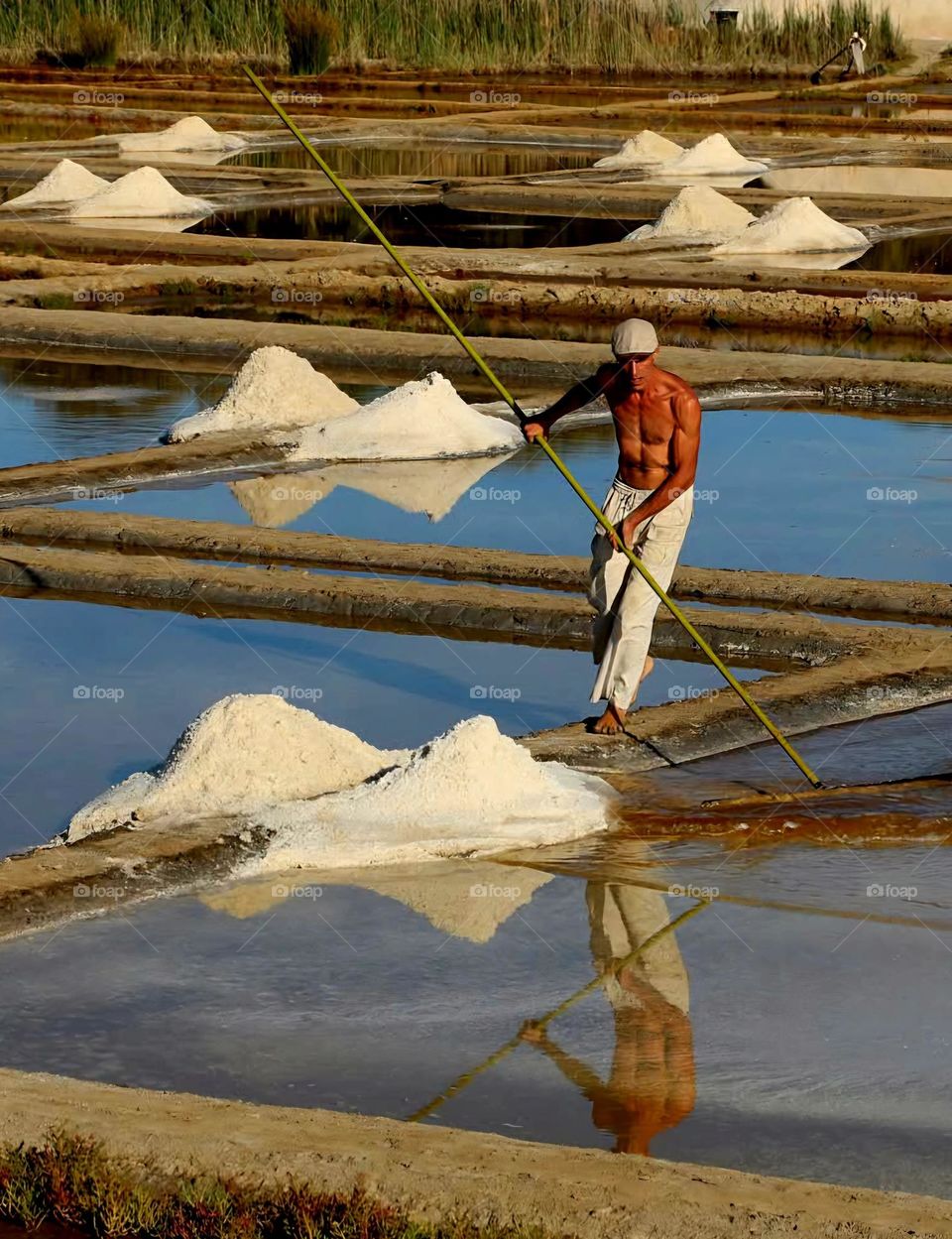 Topless salt worker at the Truscat salt ponds in Sarzeau under a blazing sun