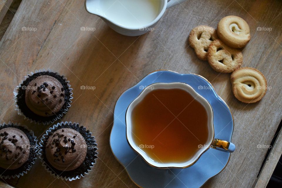 Directly shot of green tea and cupcakes
