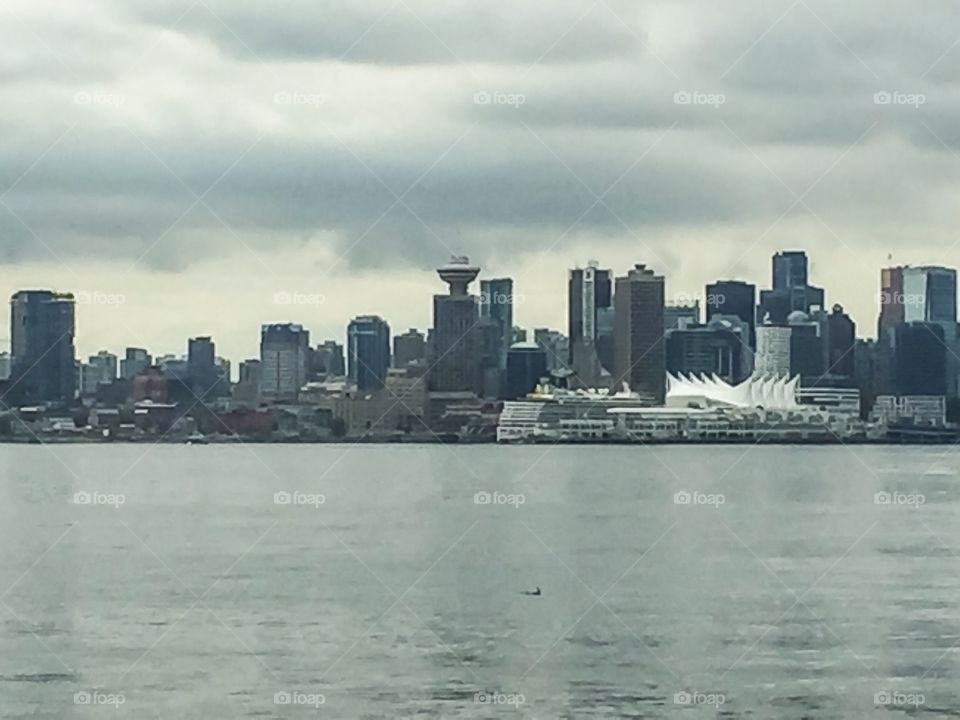 View of downtown Vancouver and Canada Place sails from Lonsdale Quay Market on a cloudy day in British Columbia 