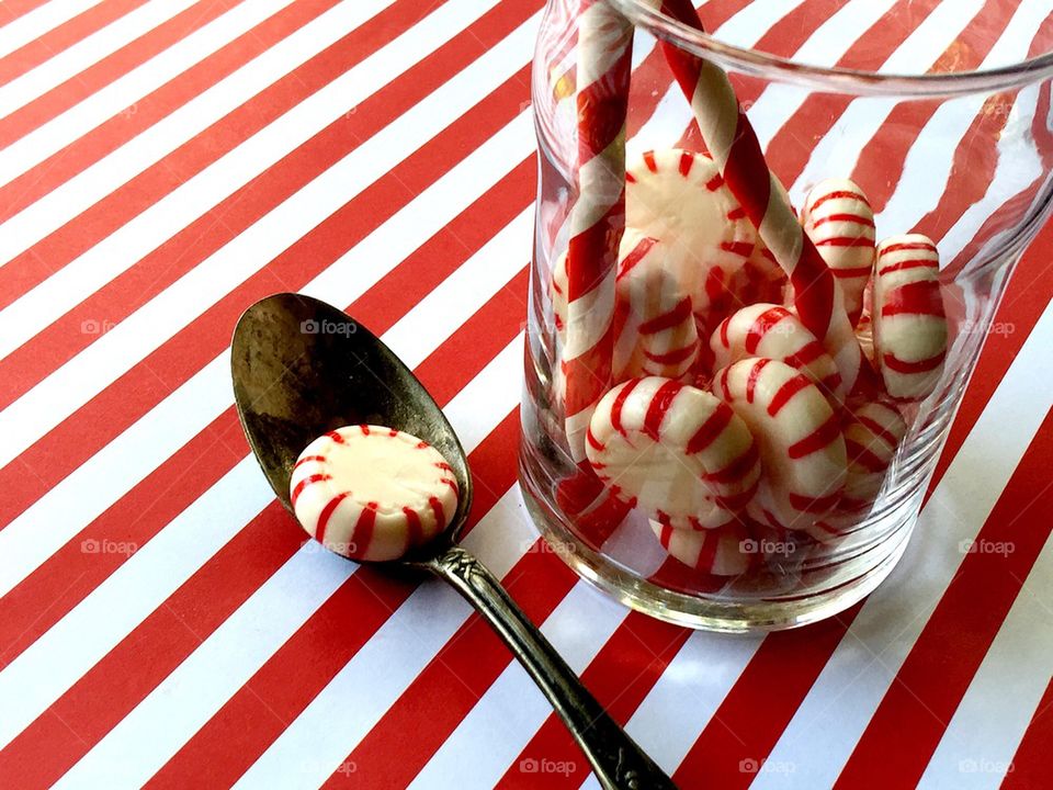 Peppermint candies in glass with straws and spoon 