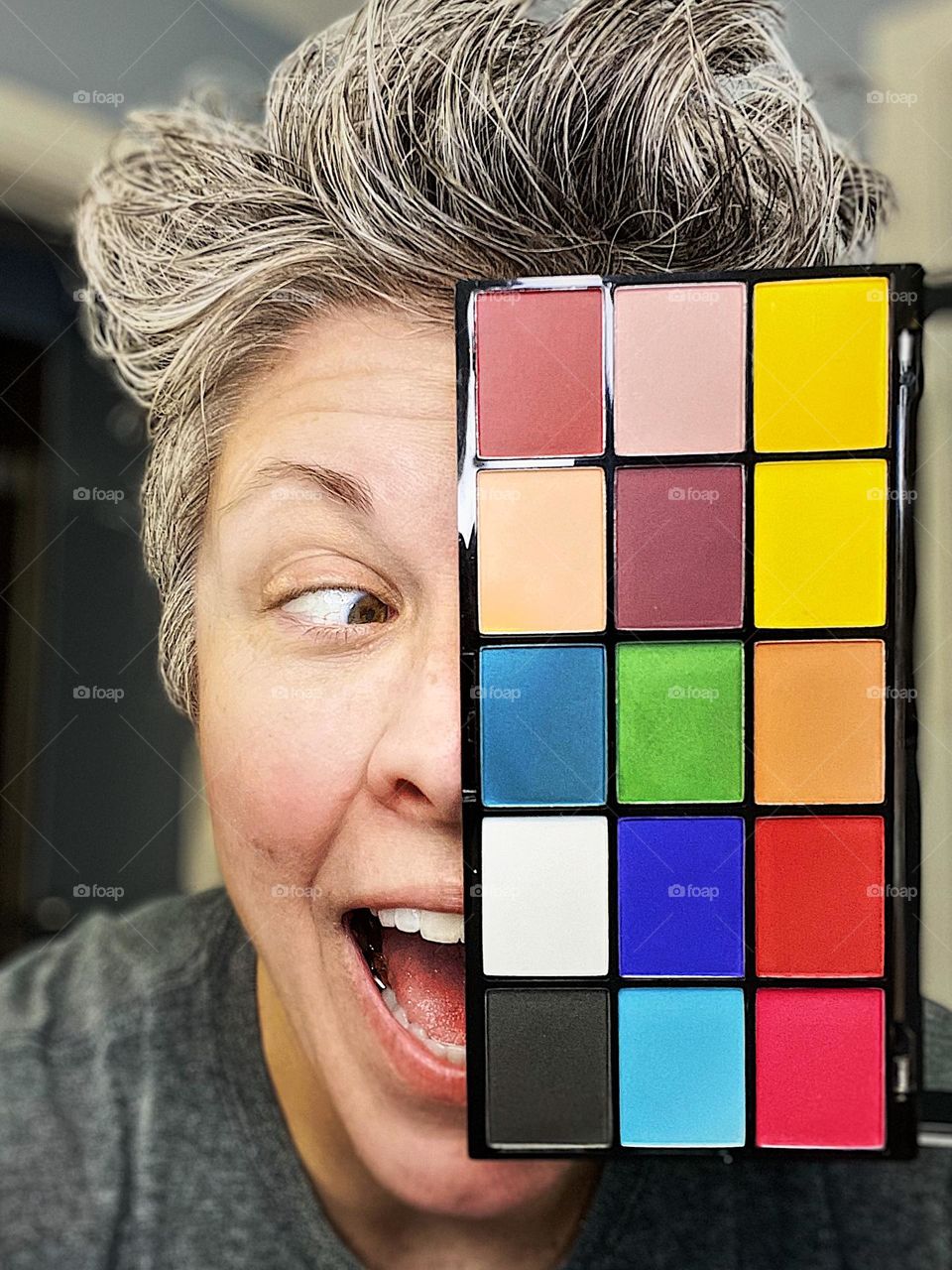 Silly woman with eye shadow, crazy eyes and makeup, funny poses with eye shadow colors, excited about eye shadow colors, eye looking to the side