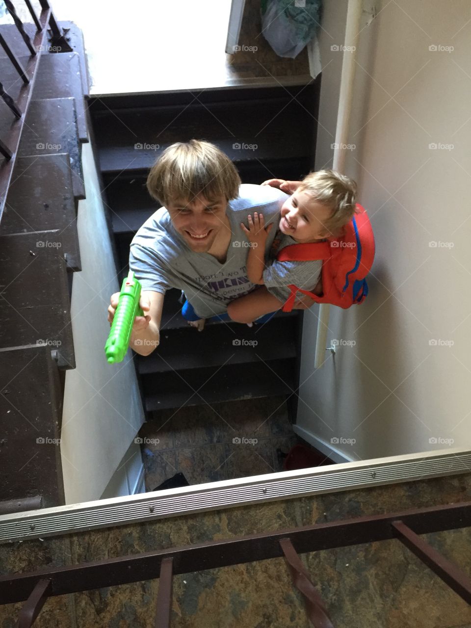 Father and son water gun mischief