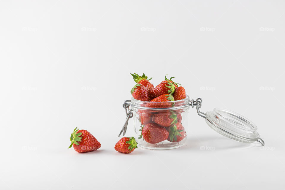 Fresh and ripe strawberries fruits in glasses jar on the table. Copy space. Concept of healthy life.