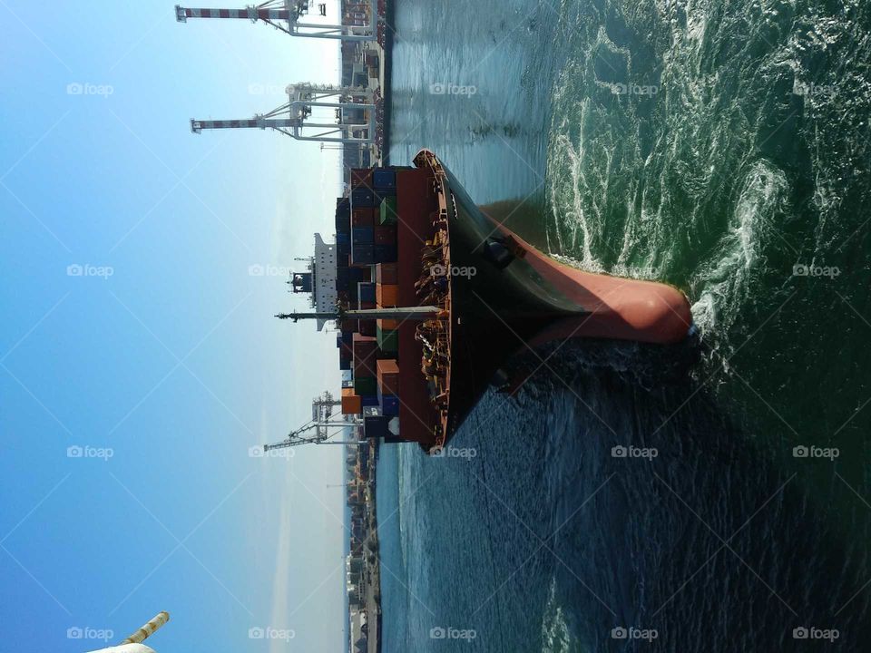 Cargo ship swinging bow to starboard arriving in port.