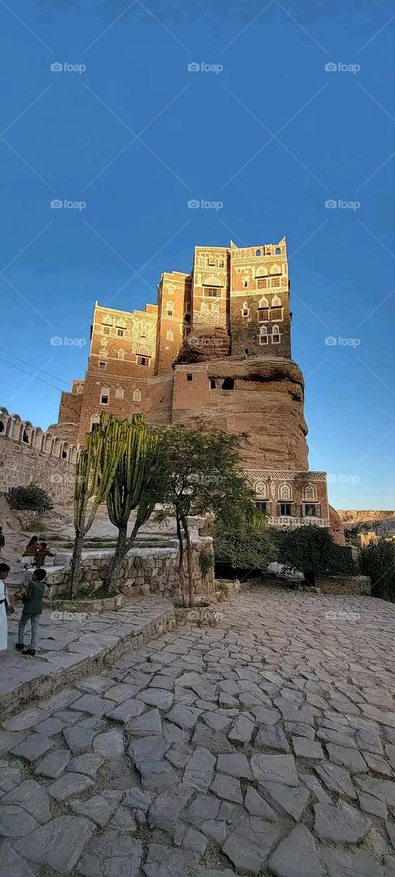 The image embodies a natural natural plate of the mountains of nature, where green agricultural stands are graded on the slopes as if they were lines of a poem, which fog harmoniously wrapped, and clouds hugged them in the mountain knife and the whis