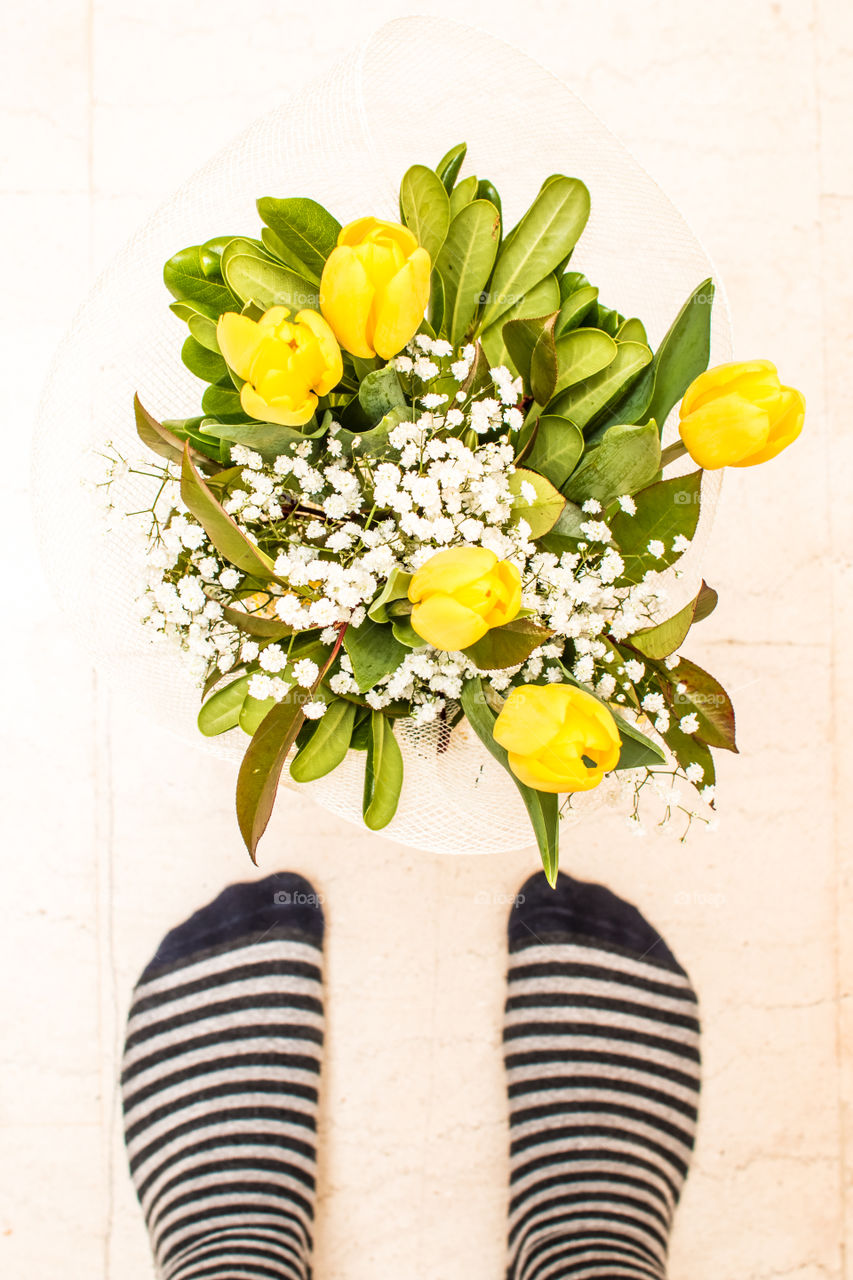 Bouquet flowers in front of feet wearing socks