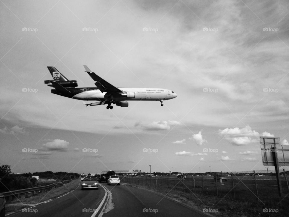Plane landing. Plane lands crossing road overhead 