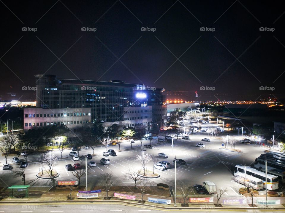 Late night view from an elevated position of a building with the front car park. Night lights. At Incheon, South Korea.
