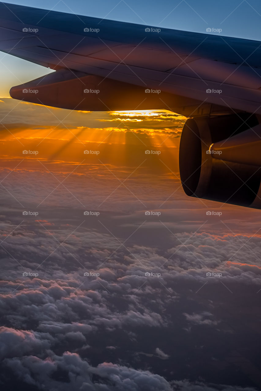 Aerial sunrise or daybreak as viewed onboard a flight 30,000 feet above Guam. The emerging light scatters in the atmosphere to form rays called the Tyndall Effect.