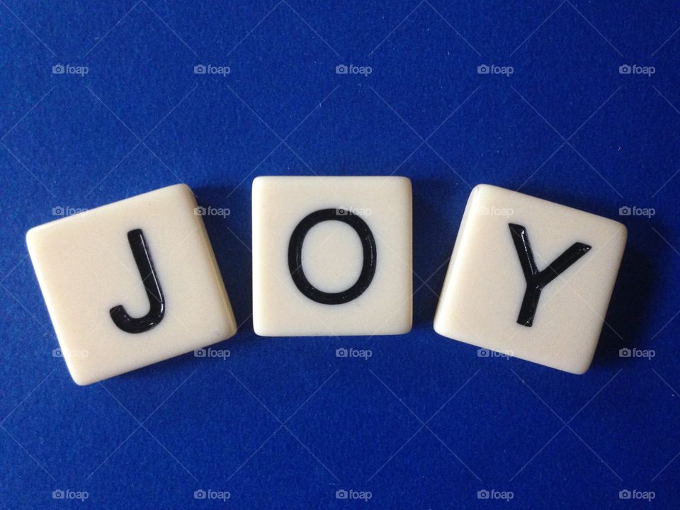 Joy. Word joy made with letter tiles