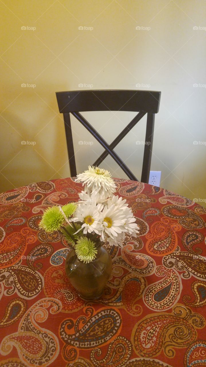 kitchen table with flowers and table cloth