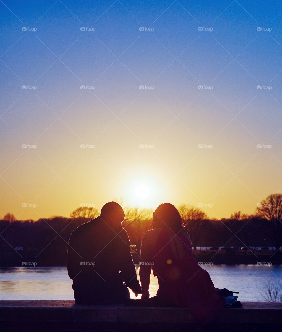 A couple enjoy a romantic embrace during sunset. 