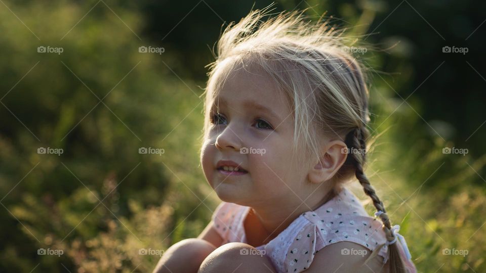 Beautiful little Caucasian girl with blonde hair outdoor at summer 