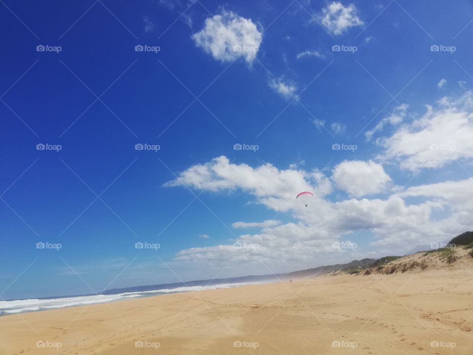 Great view of beach and clouds with a paraglyder.
