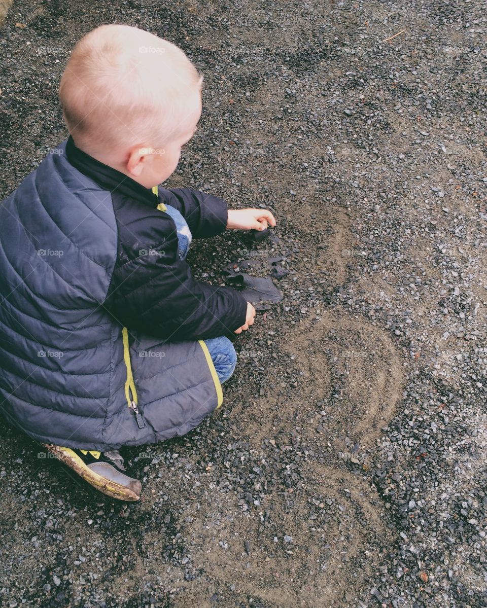 Boy drawing. A little boy drawing in the sand