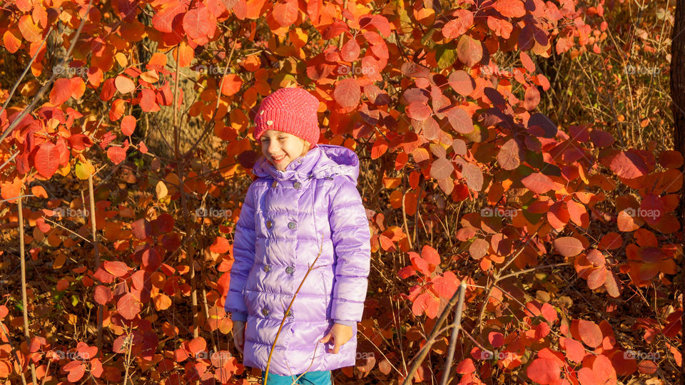 happy child against red leaves