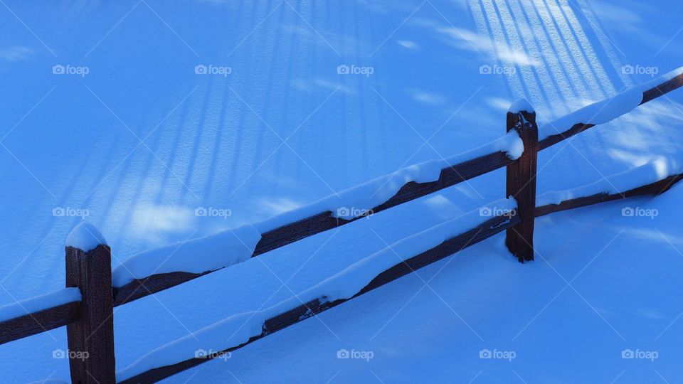 Wooden fence covered in snow