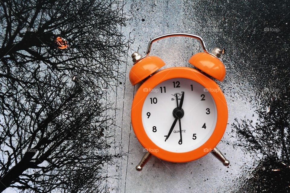 orange alarm clock on a black and white nature photography top view background composition art abstract
