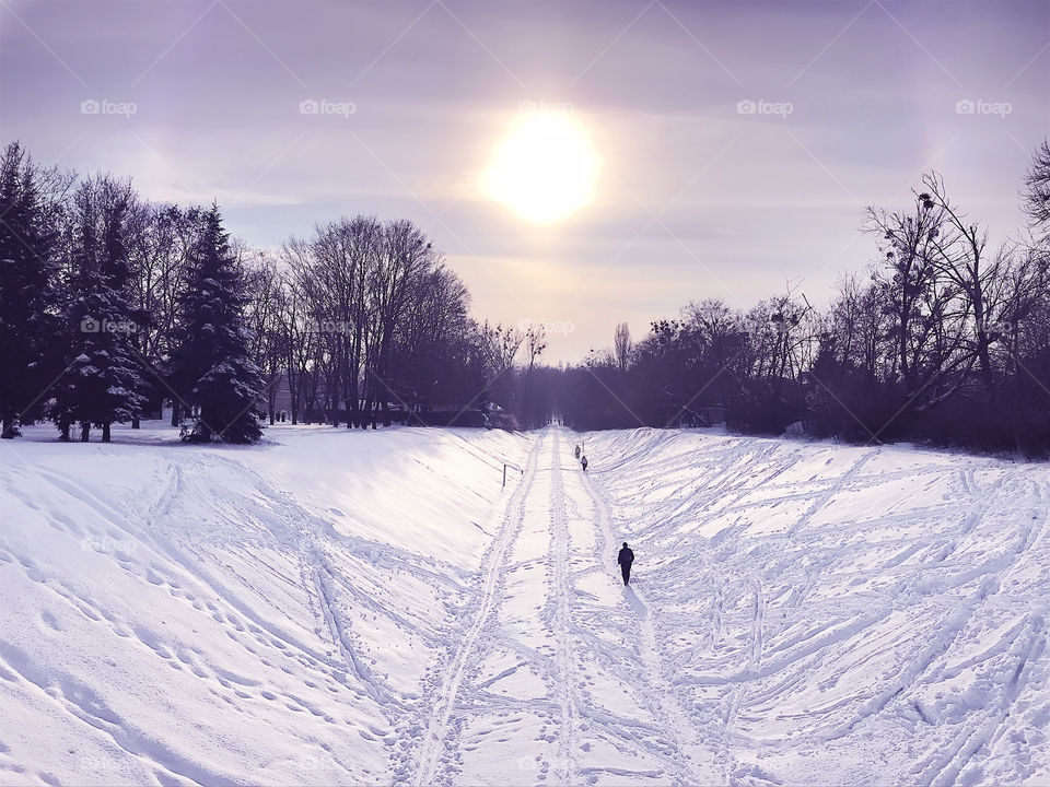 People walking under the sunset halo in winter 