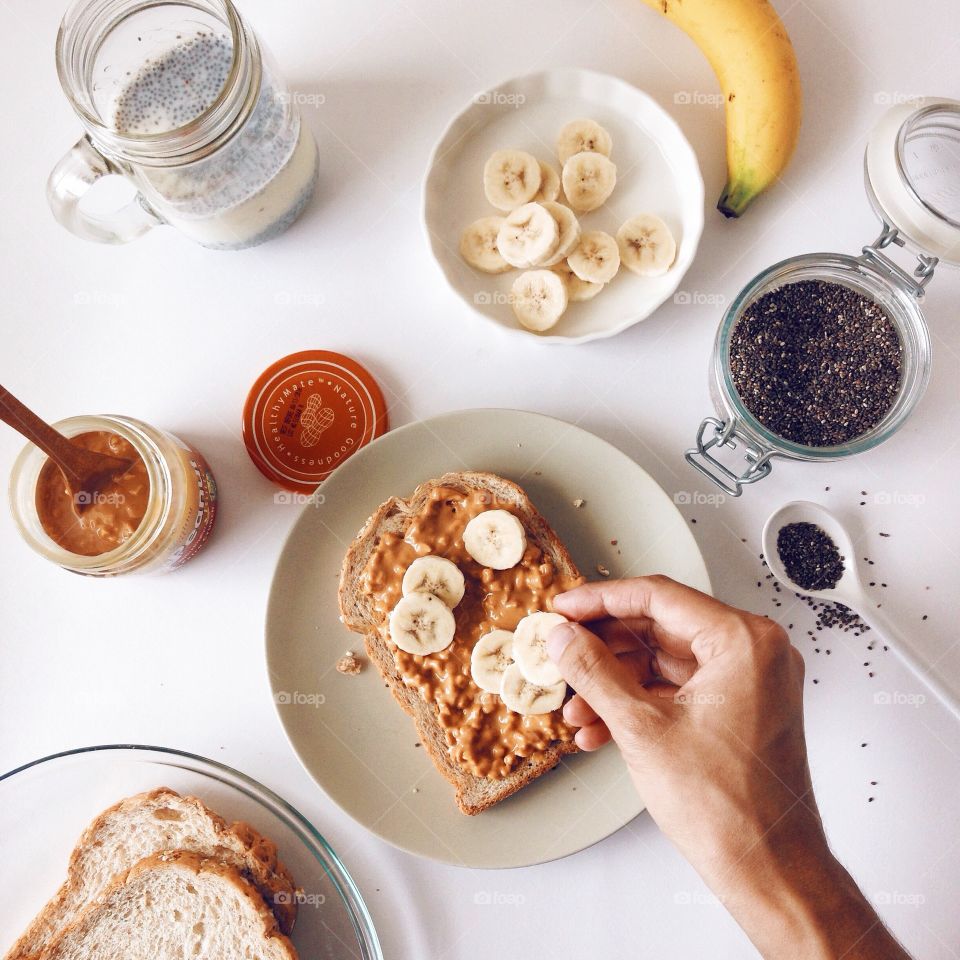 Person preparing breakfast using bread and banana